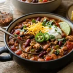 Turkey bean chili in a deep bowl with tomatoes, beans, herbs, yogurt, and a rich red sauce.