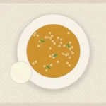 Chickpea spinach curry in coconut tomato sauce served with rice and lemon.