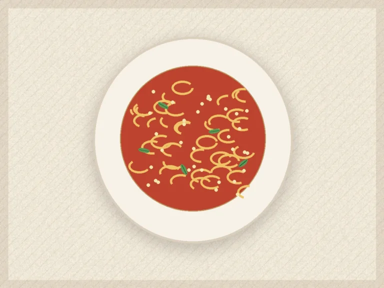 Creamy tomato spinach pasta in a shallow bowl with parmesan and black pepper.