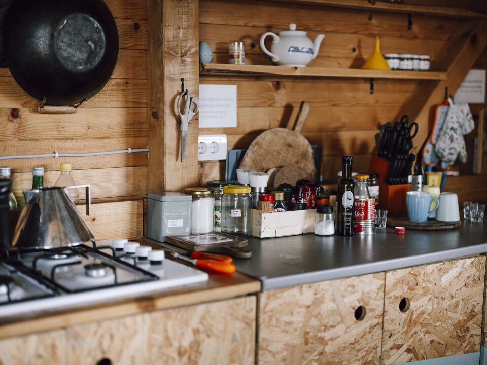 Glass jars, wooden tools, and folded linens on a lived-in kitchen counter.