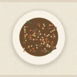 Mushroom barley stew in a bowl with carrots, herbs, and a deep savory broth.