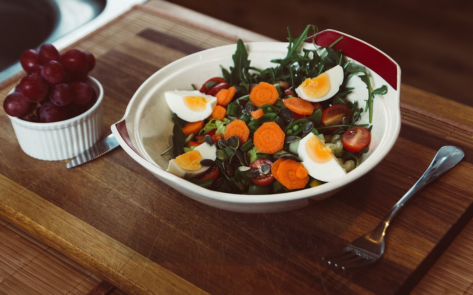 A couscous salad bowl with roasted carrots, crumbled feta, herbs, and lemon.
